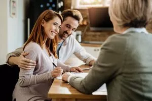 3.young-happy-woman-her-husband-signing-agreement-with-insurance-agent-meeting-300x200